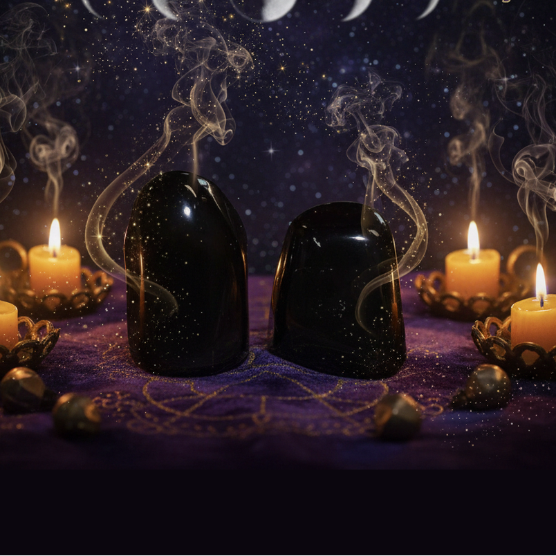 Exact pair of polished black obsidian stones with professional mystical protection atmosphere
